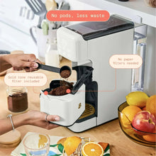 White single-serve coffee maker with reusable filter basket and brew chamber open
