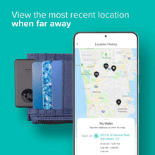 Two black Tile trackers beside a smartphone showing a location map
