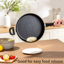 Black non-stick skillet with handles, cooking a fried egg