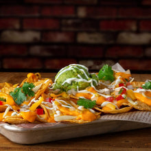 Tortilla chips with melted cheese sauce, green jalapeños, cilantro, and peppers