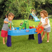 Kids playing at a blue outdoor water table with slide, accessories, and orange wheel