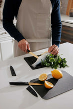 Knife set with black handled blades and cutting boards during food prep