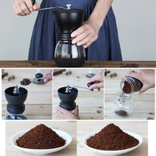 Black manual coffee grinder with metal crank handle and top knob