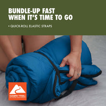 Blue rectangular sleeping bag rolled up with black elastic straps.