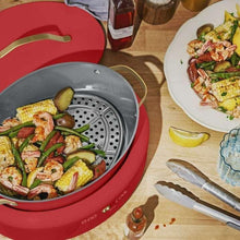 Tomato red multi-cooker with perforated steaming insert and vegetables