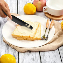 Black silicone spatula spreading toast on a plate