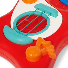 Close-up of red toy guitar sound panel with blue strings and orange knob