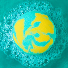 Blue-green bath fizzle sphere dissolving in bubbling water