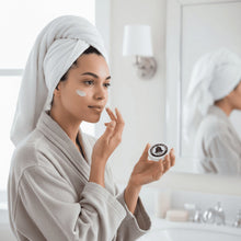 Woman applying pomade with jar held in hand