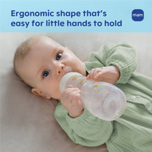 Baby holding MAM Easy Active baby bottle with clear body, beige collar and nipple