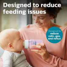 Baby drinking from a pink Philips Avent anti-colic bottle with clear nipple