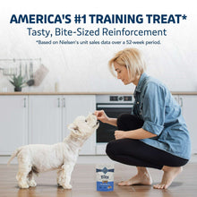 Dog training treat bag with bite-size treats held near a puppy