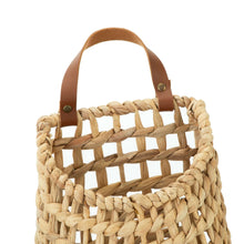 Woven water hyacinth basket top with brown faux leather handle straps and cross weave