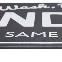 Black indoor laundry runner rug close-up of 'SAME DAY SERVICE' text