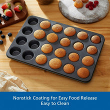 Mini muffin pan with baked mini muffins in nonstick round cups on wood