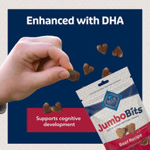 Hand placing beef-flavored dog treats beside JumboBits beef recipe bag