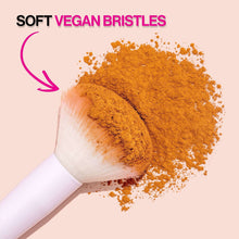 Ultra-plush eyeshadow brush bristles picking up loose brown pigment; white handle