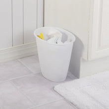 White plastic trash can with open top, holding waste near a wall.
