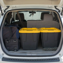Two yellow-lidded storage bins with black bodies in a vehicle trunk