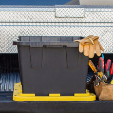 Open black storage bin with yellow base on a truck bed