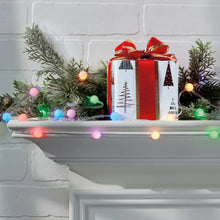 Color-changing bubble lights along a mantel garland and around gift decorations