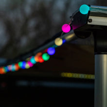 Color-changing bubble lights on an outdoor rail with multicolor bulbs