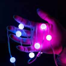 Color-changing bubble lights with glowing bulbs held in a hand