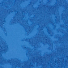 Blue textured terry towel fabric with raised sea-life shapes pattern