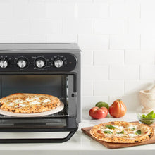 Gray air fryer oven with pizza inside, open door and front control knobs