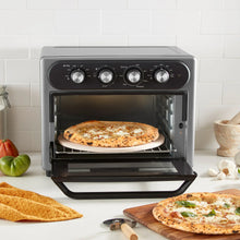 Gray air fryer oven with pizza on rack, open door and front dials visible