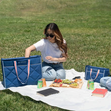 Quilted blue cooler bags set outdoors with striped handles and quilted front panels