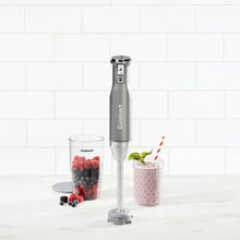 Immersion blender with two cups and base on a countertop