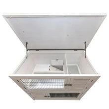 Two-story rabbit hutch with hinged top open to show interior compartments