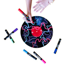 Hand using a red POSCA marker on a round stencil with scattered markers