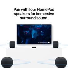 Apple TV 4K box with four HomePod speakers arranged around a TV
