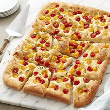 Baked cookie bars on dark non-stick baking sheet with parchment