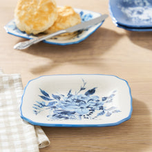 Blue stoneware appetizer plate with blue floral medallion, scalloped edge