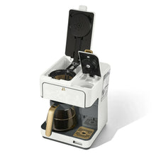 White coffee maker with lid open, showing water chamber and brew funnel