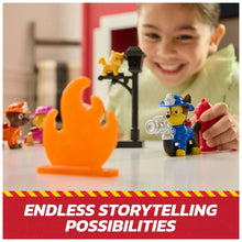 Child smiling while holding blue fire rescue dog figure near orange flame accessory