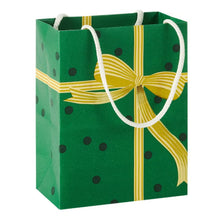 Green gift bag with a gold ribbon bow print, dark dots and white rope handles