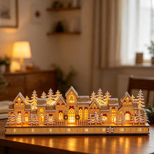 Wooden village Advent calendar with numbered drawers, snowy houses, trees, and warm LED lights