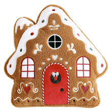 Gingerbread house pillow with a red door, wreath, windows, and icing details