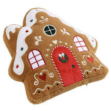 Gingerbread house pillow shown at an angle, with a red door and icing details