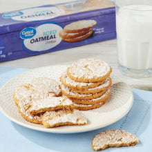 Iced oatmeal cookies stack on plate, with cookie bag behind