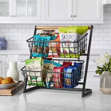Two-tier fruit basket stand with black wire baskets and bamboo handle, stacked with snack boxes