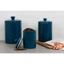 3-piece navy blue ceramic canister set with sea-shell pattern; one canister filled with beans