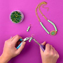 Jewelry tools in use with beaded necklace chain and matching green bead earrings