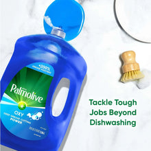 Palmolive Oxy dish liquid bottle, blue with pump cap beside a dish brush