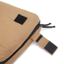 Tan sleeping bag close-up of zipper track, black pull tab, and binding