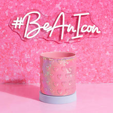 Pink iridescent utensil crock with embossed hearts, resting on counter